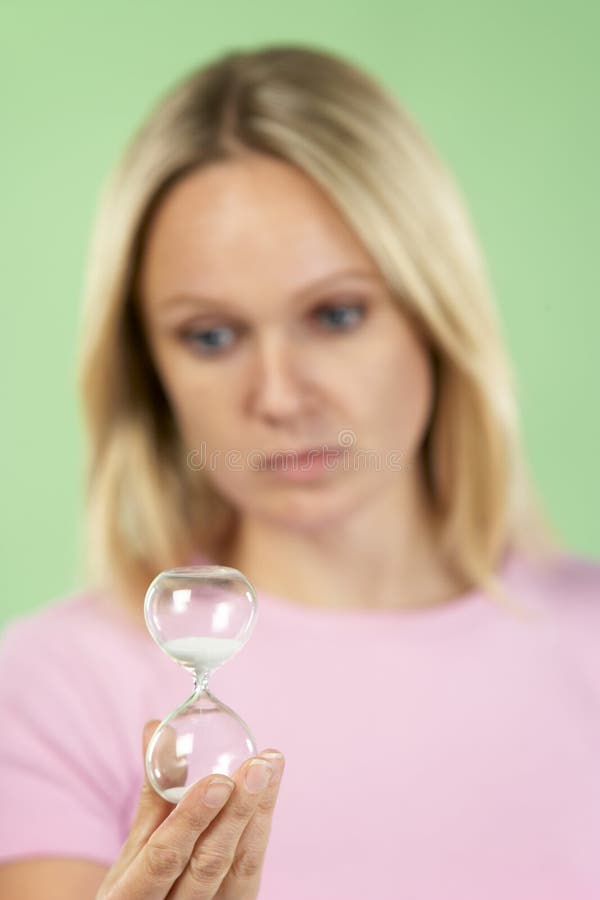 Hourglass da terra arrendada da mulher fotografia de stock royalty free Hourglass da terra arrendada da mulher fotografia de stock royalty free