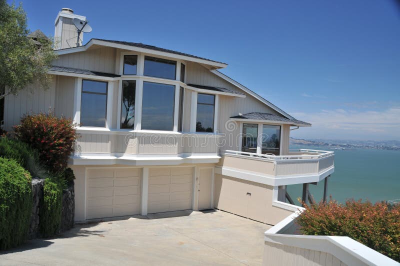 House with bay in background reflecting windows