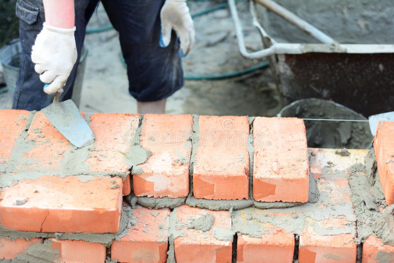 Bricklaying, Brickwork. Bricklayer Worker Installing Red