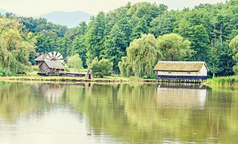 House build on water, straw roof, near lake and green forest royalty free stock photo House build on water, straw roof, near lake and green forest royalty free stock photo