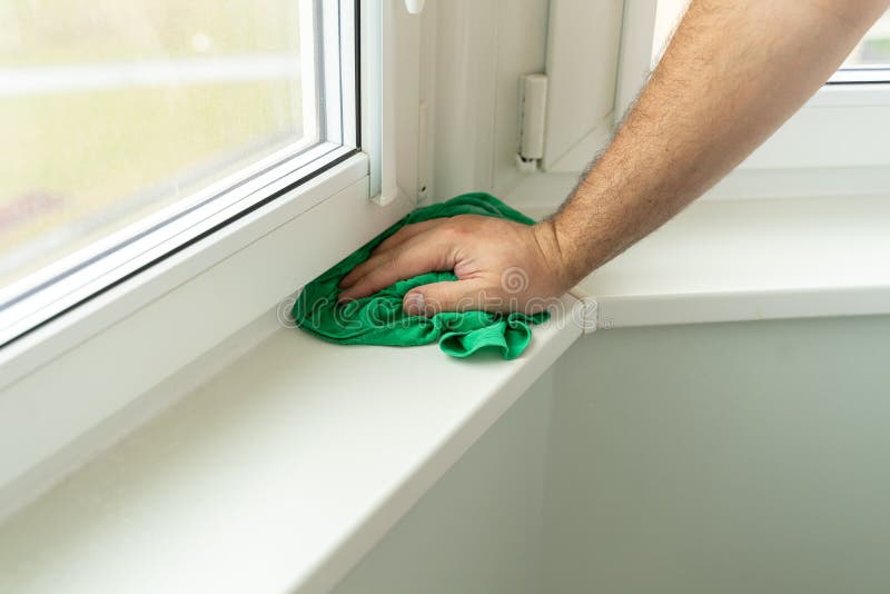 House cleaning. man`s hand washes a window. a man washes windows in a car with a special appliance.