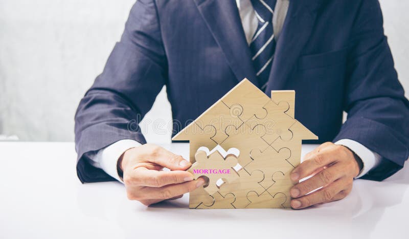 The house and coins are placed on a piece of puzzles with last piece with text mortgage. royalty free stock images The house and coins are placed on a piece of puzzles with last piece with text mortgage. royalty free stock images