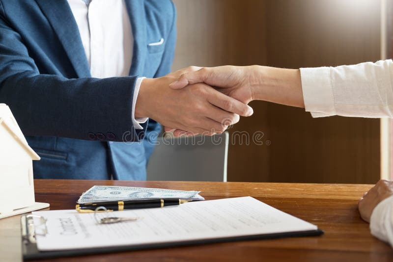 House developers agent or financial advisor and customers shaking hands after signing document making deal as successful.
