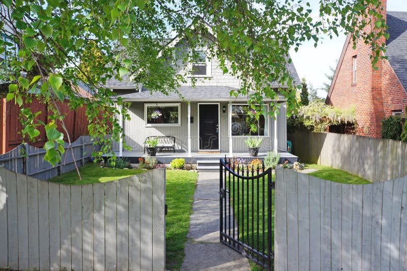 Small old house. Front fenced yard with open gate. View of walkway and entrance porch. Small old house. Front fenced yard with open gate. View of walkway and entrance porch