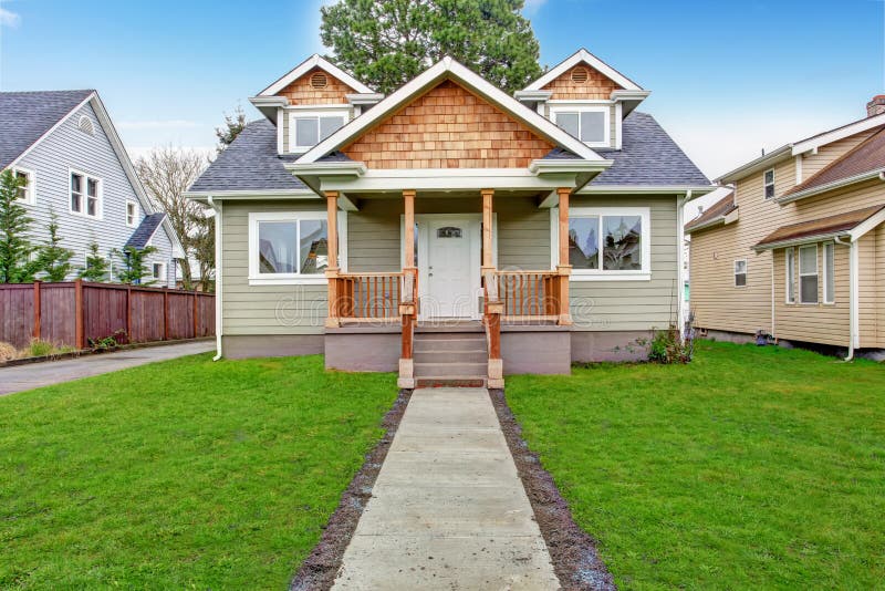 Small house with wooden column porch. View from walkway. Small house with wooden column porch. View from walkway