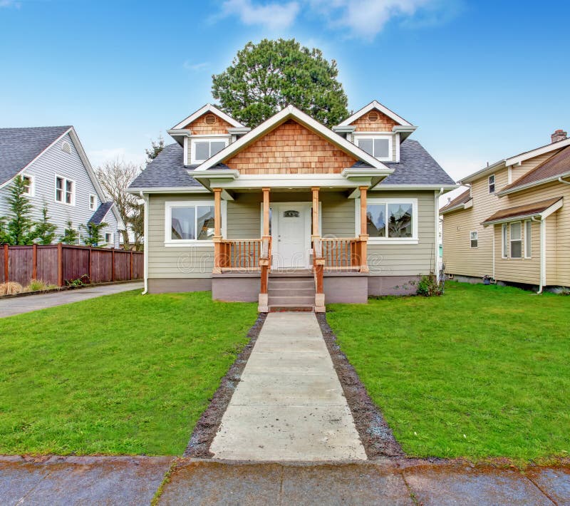 Small house with wooden column porch. View from walkway. Small house with wooden column porch. View from walkway