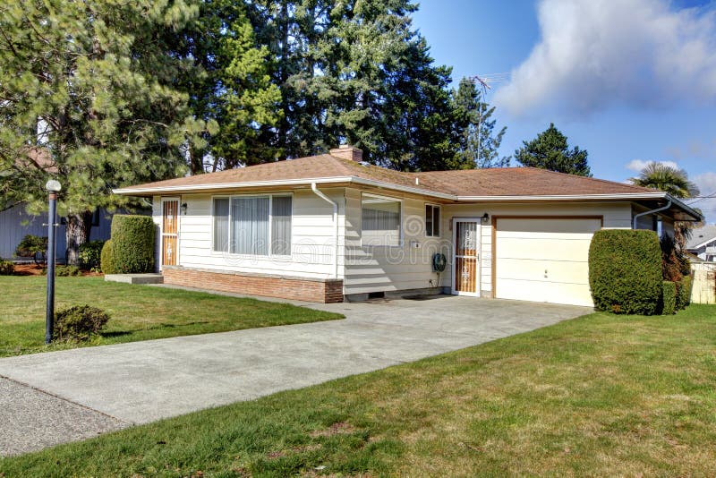 Tile roof siding house with a garage and concrete drive way. Tile roof siding house with a garage and concrete drive way