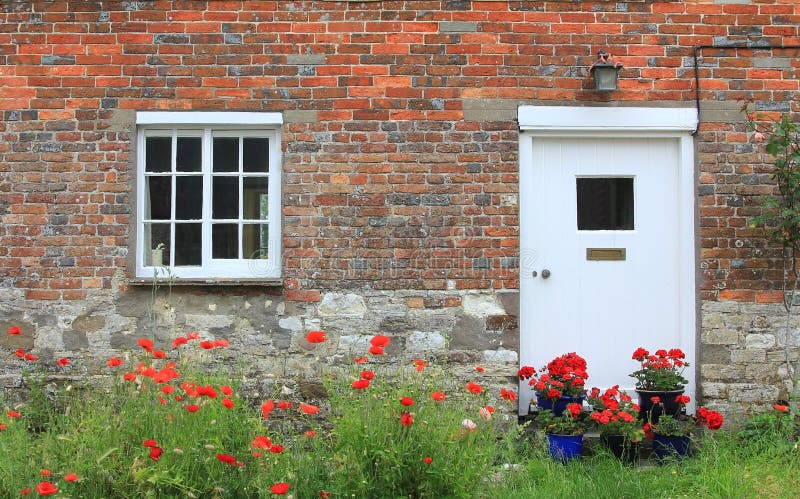 House front with red poppy flowers and geraniums. Rustic house front with red poppy flowers and geraniums royalty free stock photo House front with red poppy flowers and geraniums. Rustic house front with red poppy flowers and geraniums royalty free stock photo