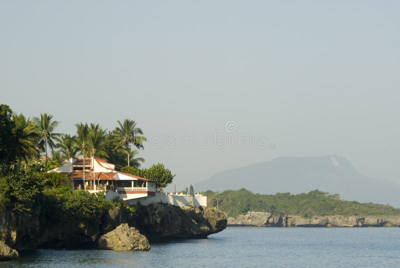 House on cliff over the sea with island in distance. House on cliff over the sea with island in distance