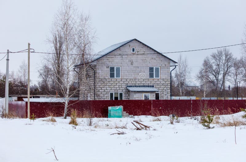 A house with a red fence and a green trash can in front of it stock photos