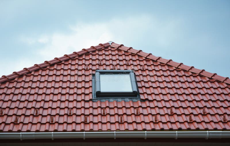 House roof window, sun tunnel skylights or skylight after rain on red clay roof tiles. Attic skylight solution outdoor. Roofing.