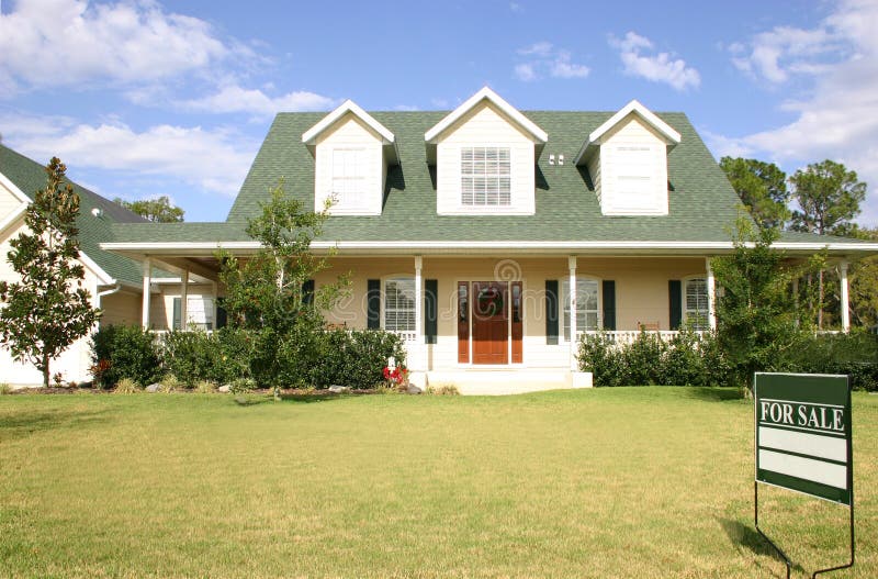 In stile americano, casa per vendita, bianco withgreen tetto e serramenti, tre abbaini, wrap-around, portico, portone rosso, prato e del paesaggio.