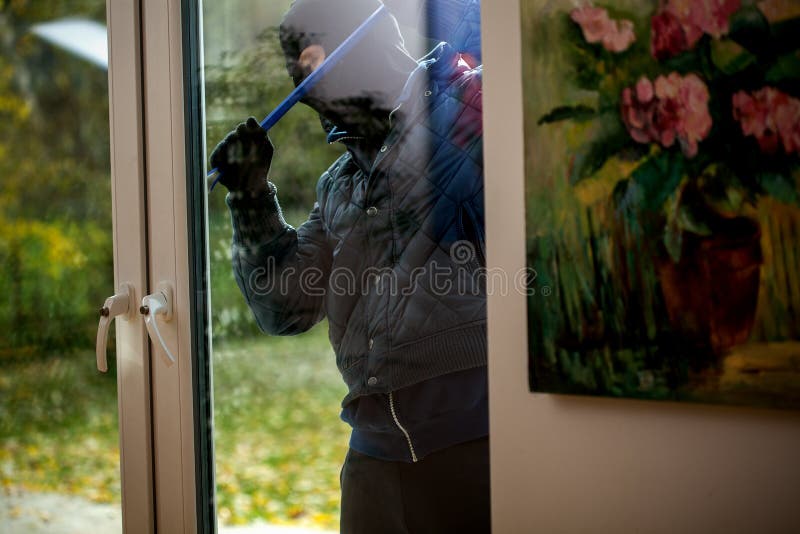 Burglar trying to open the window with crowbar