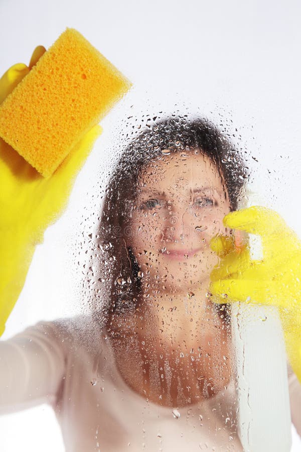 Attractive young woman cleaning windows. All isolated on white background. Attractive young woman cleaning windows. All isolated on white background.