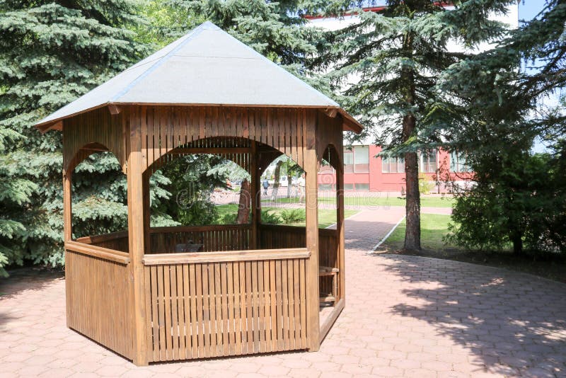 Houten bruin paviljoen voor rust op een achtergrond van groene sparren stock foto's Houten bruin paviljoen voor rust op een achtergrond van groene sparren stock foto's