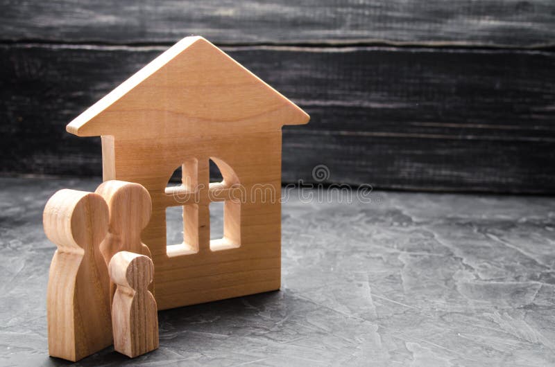 Houten cijfers van de familietribune dichtbij een blokhuis Het concept het vinden van een nieuw huis, het bewegen zich Een gezond stock afbeeldingen Houten cijfers van de familietribune dichtbij een blokhuis Het concept het vinden van een nieuw huis, het bewegen zich Een gezond stock afbeeldingen