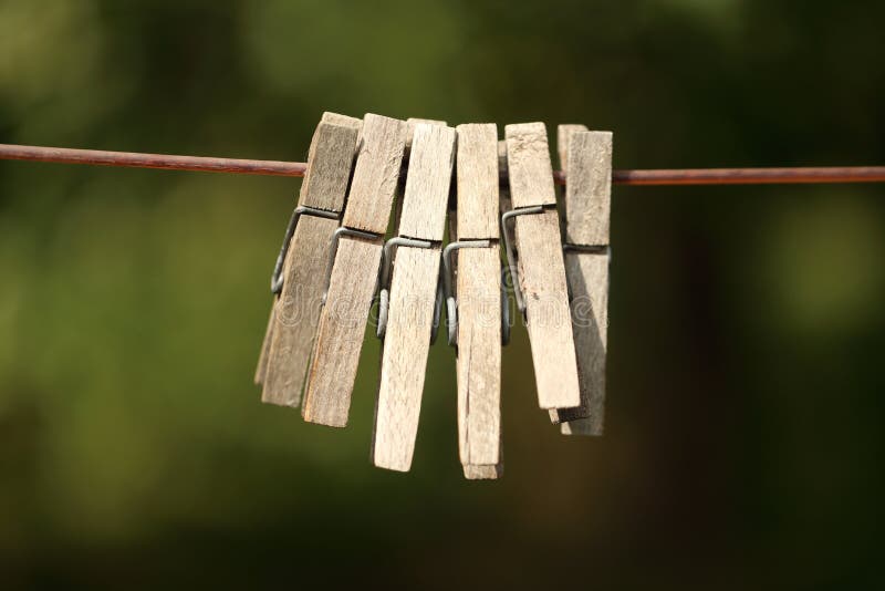 Houten die wasknijpers op kabel bij tuin worden gehangen stock foto Houten die wasknijpers op kabel bij tuin worden gehangen stock foto