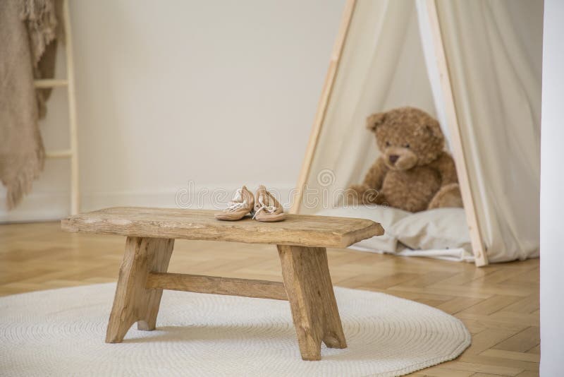 Houten kruk met schoenen op witte ronde deken in het binnenland van de jong geitje` s ruimte met pluchestuk speelgoed in tent stock fotografie Houten kruk met schoenen op witte ronde deken in het binnenland van de jong geitje` s ruimte met pluchestuk speelgoed in tent stock fotografie