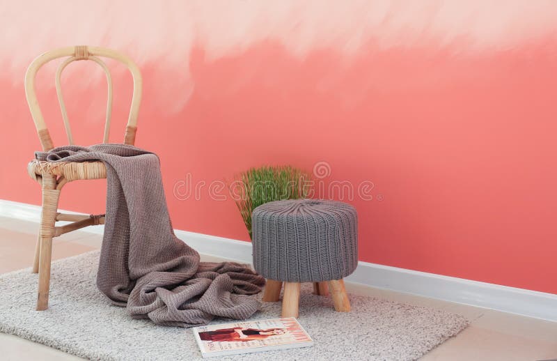 Houten stoel met ottomane dichtbij roze muur royalty-vrije stock afbeeldingen Houten stoel met ottomane dichtbij roze muur royalty-vrije stock afbeeldingen