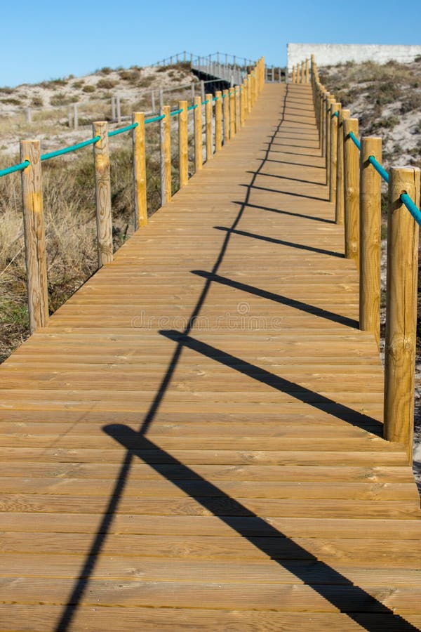 Houten weg met omheining aan het strand Gang op kust in de ochtend De kust van de Atlantische Oceaan in Portugal stock afbeelding Houten weg met omheining aan het strand Gang op kust in de ochtend De kust van de Atlantische Oceaan in Portugal stock afbeelding