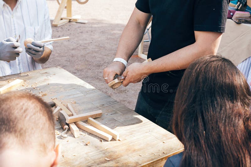 Houten workshop Overhandigt snijdende lepel van hout, die met dicht omhoog beitel werken Proces om houten lepel, beitel en spaand royalty-vrije stock afbeeldingen Houten workshop Overhandigt snijdende lepel van hout, die met dicht omhoog beitel werken Proces om houten lepel, beitel en spaand royalty-vrije stock afbeeldingen