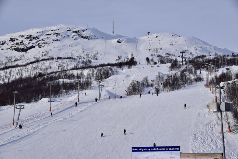 Hovden Alpinsenter, ski resort, Norway, with ski slopes. Mountain with snow and trees, people skiing and snowboarding. B.