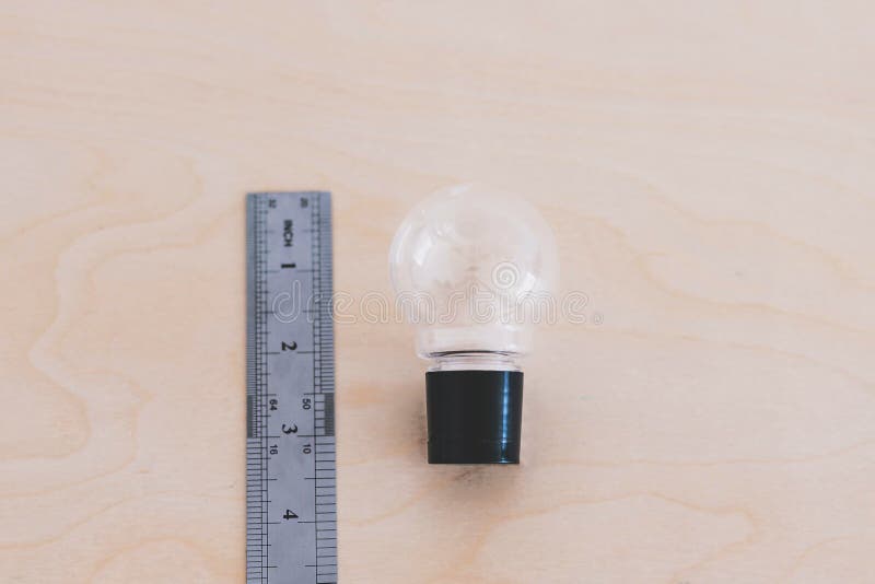 How big are your ideas, lightbulb on desk next to ruler