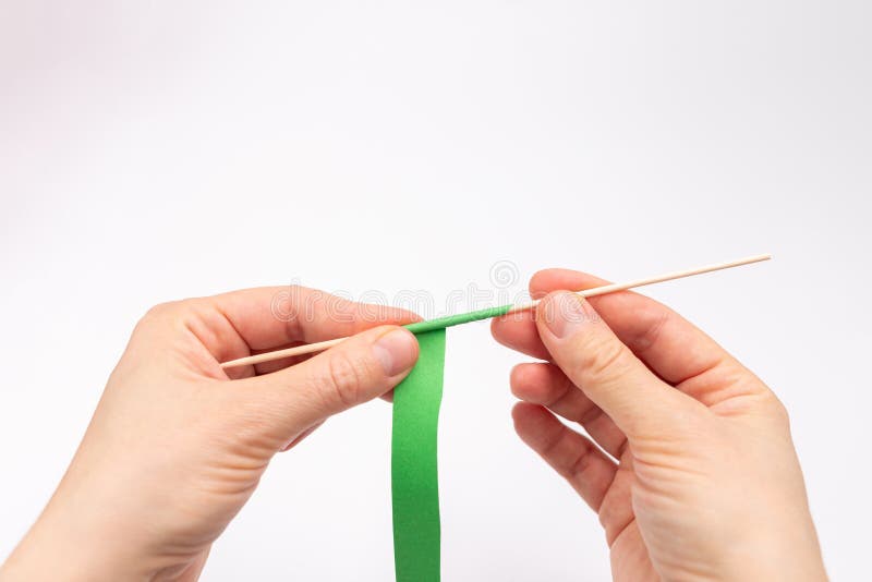 How to make a stem out of paper, twisting a green strip on a thin stick, paper crafts stock images