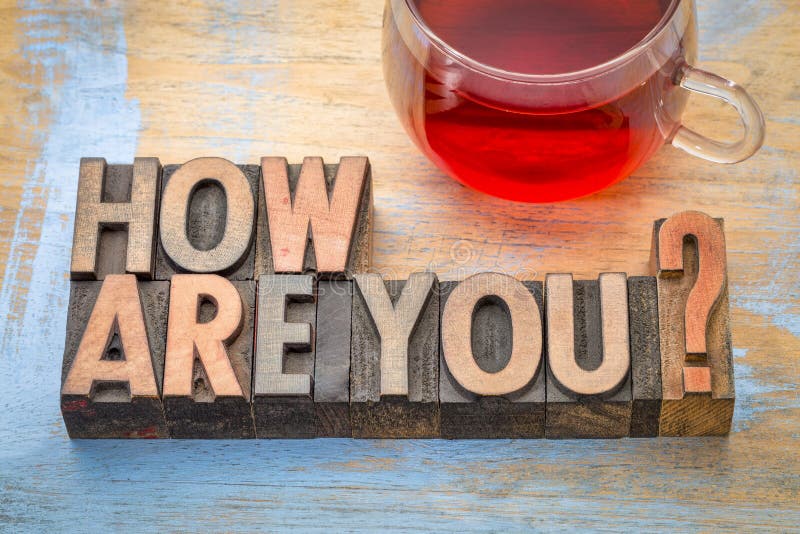How are you? A word abstract in vintage letterpress wood type printing blocks with a cup of tea