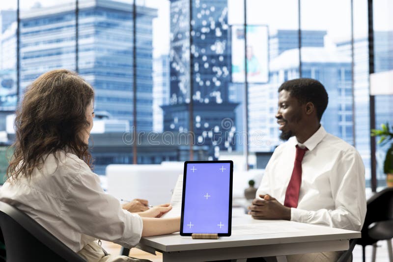 HR team browsing through applicant CVs on mockup tablet stock photo