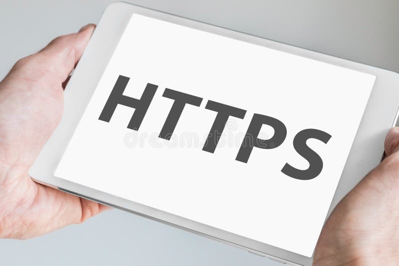 نص HTTPS معروض على شاشة اللمس لجهاز لوحي حديث. أيد تحمل جهازًا محمولاً تصوير ستوك خالي من الحقوق