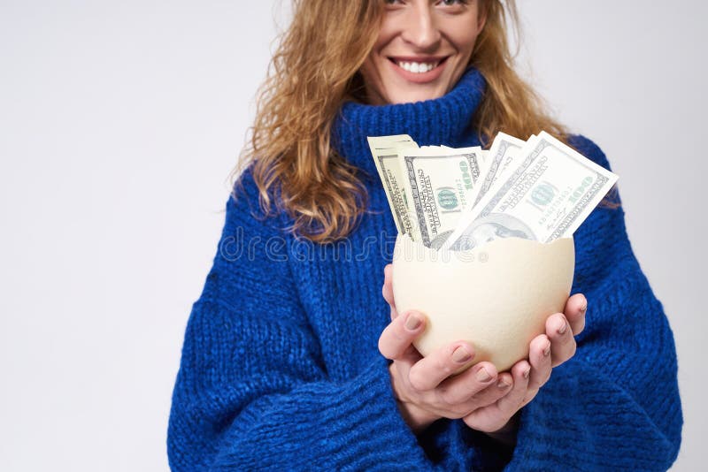Hucha del huevo de la tenencia de la mujer con el dinero a disposición fotos de archivo Hucha del huevo de la tenencia de la mujer con el dinero a disposición fotos de archivo