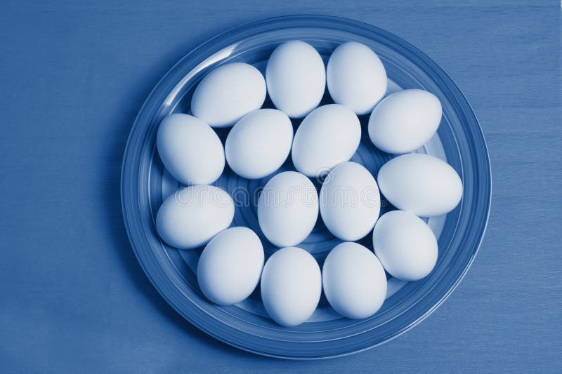 Huevos de Pascua en plato colorido y fondo azul pintado en el clásico color azul trendy del año 2020 fotos de archivo Huevos de Pascua en plato colorido y fondo azul pintado en el clásico color azul trendy del año 2020 fotos de archivo