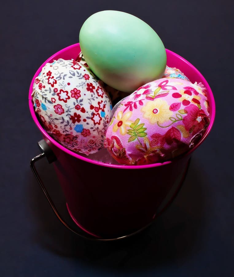 Huevos de Pascua en un cubo rosado con los huevos iluminados fotos de archivo libres de regalías Huevos de Pascua en un cubo rosado con los huevos iluminados fotos de archivo libres de regalías