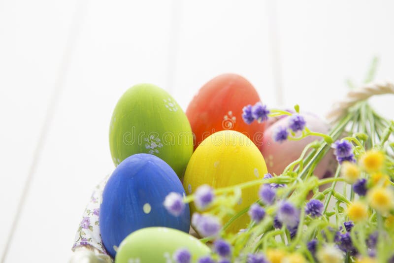 Huevos de Pascua multicolores en cesta con las flores imágenes de archivo libres de regalías Huevos de Pascua multicolores en cesta con las flores imágenes de archivo libres de regalías