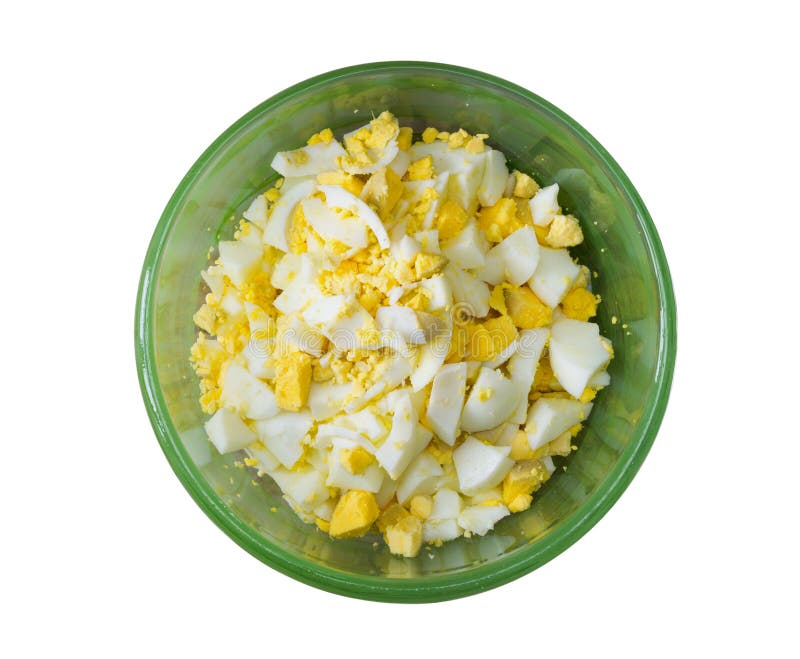 Huevos hervidos cortados en trozos pequeños en un cuenco verde aislado en el fondo blanco foto de archivo Huevos hervidos cortados en trozos pequeños en un cuenco verde aislado en el fondo blanco foto de archivo