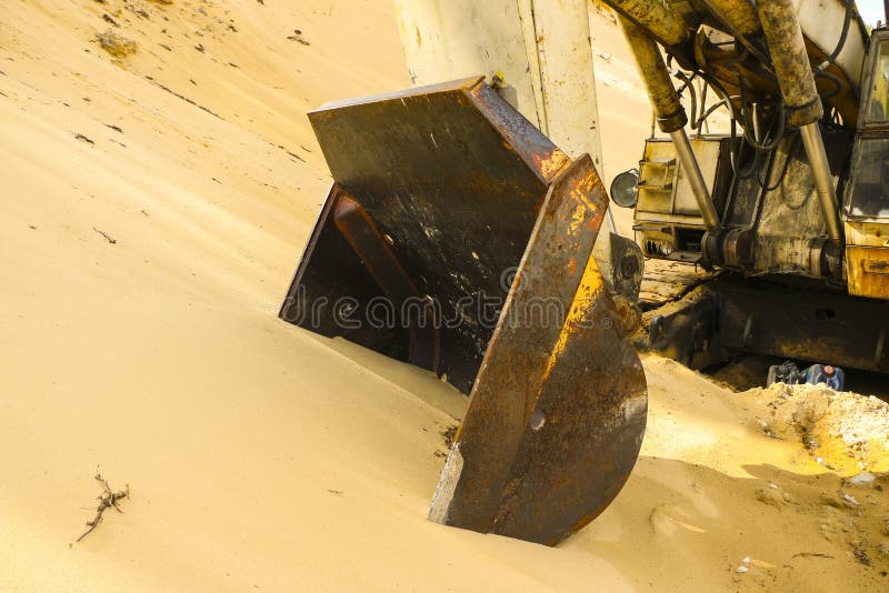 Huge Excavator Bucket Digs Sand in Sand Quarry Mining Stock Photo