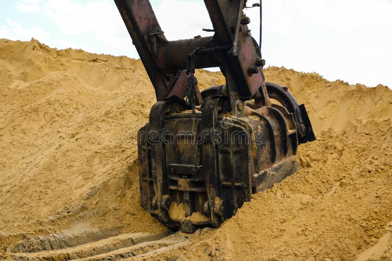 Huge Excavator Bucket Digs Sand in Sand Quarry Mining Stock Photo