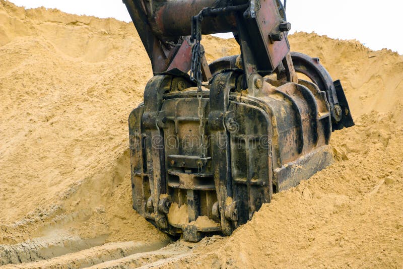 Huge Excavator Bucket Digs Sand in Sand Quarry Mining Stock Photo