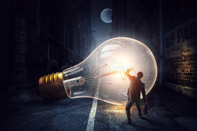 Huge light bulb glowing in the darkness royalty free stock images