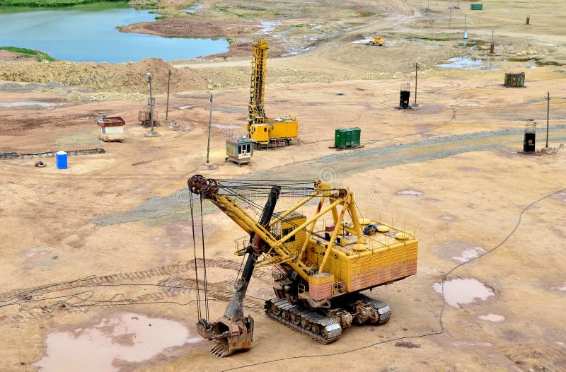 Huge mining excavator in the limestone open-pit. Biggest digger working in dolomite quarry. Largest tracked machine with electric royalty free stock photo