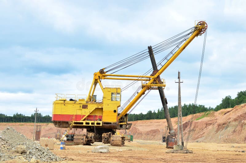 Huge mining excavator in the limestone open-pit. Biggest digger working in dolomite quarry. Largest tracked machine with electric royalty free stock photo