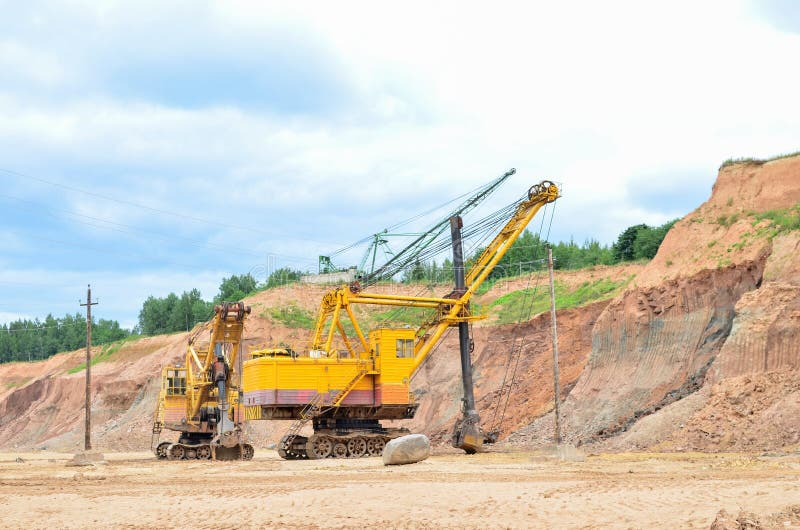 Huge mining excavator in the limestone open-pit. Biggests digger working in dolomite quarry. Largest tracked machine with electric royalty free stock photo