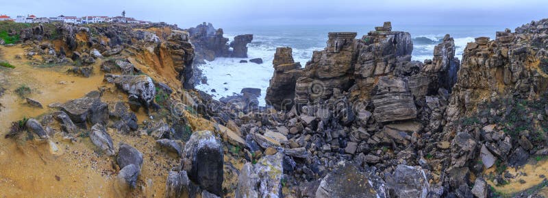 A huge ocean waves breaking on the coastal cliffs in at the cloudy stormy day. Breathtaking romantic panoramic seascape of ocean