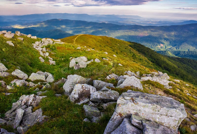 Huge rocky formations on the grassy hills. beautiful mountain landscape in late summer on a cloudy day. location Runa mountain, Ukraine