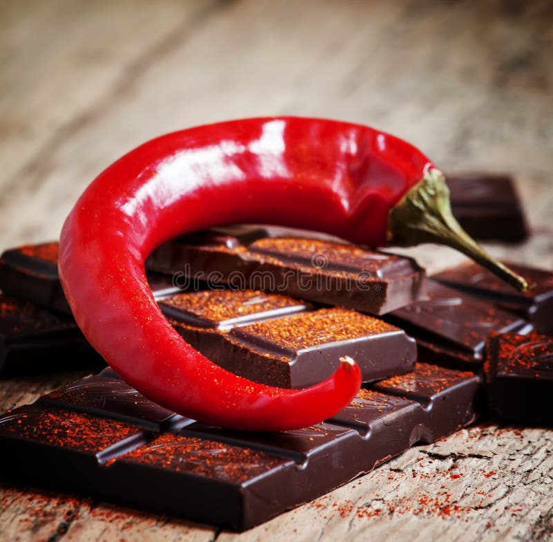 Huggen av mörk choklad, peppar för röd chili och röd peppar, selecti arkivbild Huggen av mörk choklad, peppar för röd chili och röd peppar, selecti arkivbild