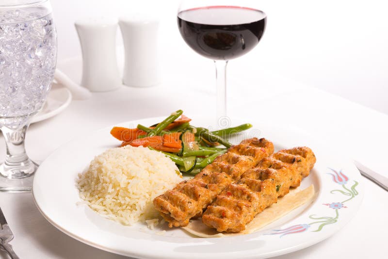 Huhn Adana Kebap gedient mit Reis-Pilaf-Gemüse und Rot VI lizenzfreie stockfotografie Huhn Adana Kebap gedient mit Reis-Pilaf-Gemüse und Rot VI lizenzfreie stockfotografie