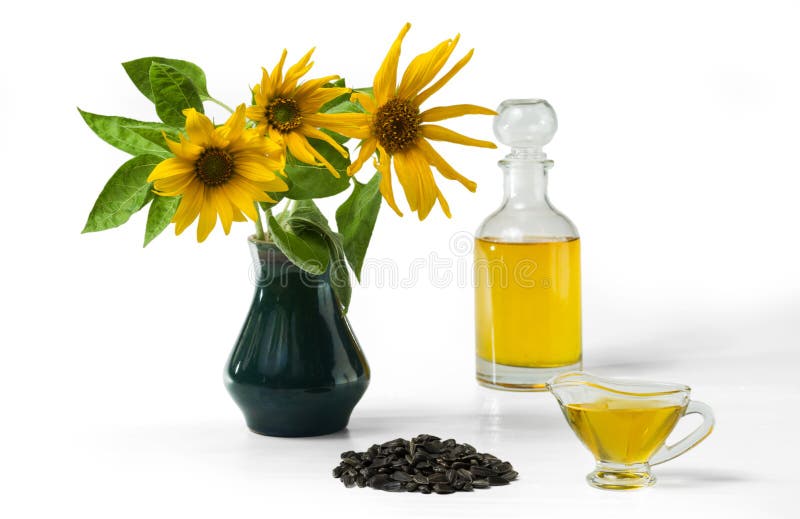 Huile de tournesol dans un bateau de sauce au jus en verre, dans une bouteille, et une poignée de graines de tournesol, et d'un t images stock Huile de tournesol dans un bateau de sauce au jus en verre, dans une bouteille, et une poignée de graines de tournesol, et d'un t images stock