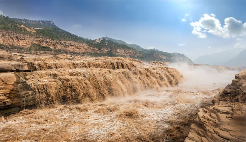 The Hukou Waterfall, is the largest waterfall on the Yellow River, China, the second largest waterfall in China after the Huangguoshu Waterfall, and the world`s largest yellow waterfall. It is located at the intersection of Shanxi Province and Shaanxi Province, 165 km 103 mi to the west of Fenxi City, and 50 km 31 mi to the east of Yichuan where the middle reaches of the Yellow River flow through Jinxia Grand Canyon. The width of the waterfall changes with the season, usually 30 metres 98 ft wide but increasing to 50 m 164 ft during flood season. It has a height of over 20 m 66 ft. When the Yellow River approaches the Hukou Mountain, blocked by mountains on both sides, its width is abruptly narrowed down to 20 m 66 ft - 30 m 98 ft. The water`s velocity increases, and then plunges over a narrow opening on a cliff, forming a waterfall 15 m 49 ft high and 20 m 66 ft wide, as if water were pouring down from a huge teapot. Hence it gets the name Hukou literally, `flask mouth` Waterfall. The Hukou Waterfall, is the largest waterfall on the Yellow River, China, the second largest waterfall in China after the Huangguoshu Waterfall, and the world`s largest yellow waterfall. It is located at the intersection of Shanxi Province and Shaanxi Province, 165 km 103 mi to the west of Fenxi City, and 50 km 31 mi to the east of Yichuan where the middle reaches of the Yellow River flow through Jinxia Grand Canyon. The width of the waterfall changes with the season, usually 30 metres 98 ft wide but increasing to 50 m 164 ft during flood season. It has a height of over 20 m 66 ft. When the Yellow River approaches the Hukou Mountain, blocked by mountains on both sides, its width is abruptly narrowed down to 20 m 66 ft - 30 m 98 ft. The water`s velocity increases, and then plunges over a narrow opening on a cliff, forming a waterfall 15 m 49 ft high and 20 m 66 ft wide, as if water were pouring down from a huge teapot. Hence it gets the name Hukou literally, `flask mouth` Waterfall.