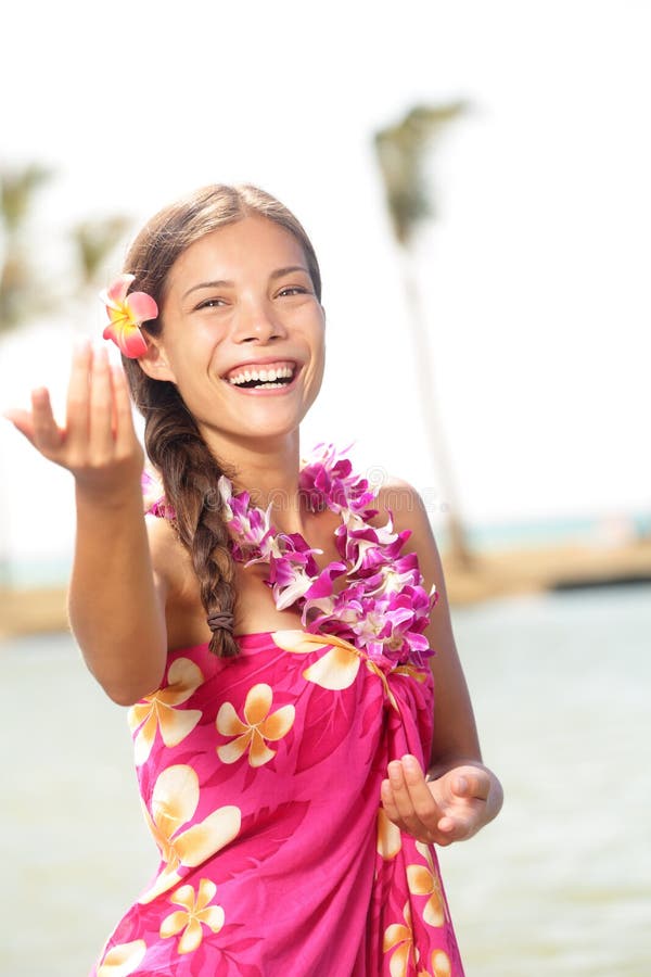 Hula dancer woman dancing hula dance on Hawaii wearing Hawaiian orchid flower lei smiling happy on beach. Travel vacation summer holidays image of beautiful mixed race girl in colorful pink sarong. Hula dancer woman dancing hula dance on Hawaii wearing Hawaiian orchid flower lei smiling happy on beach. Travel vacation summer holidays image of beautiful mixed race girl in colorful pink sarong.